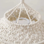 Zoom sur les détails du tissage en macramé d'un abat-jour bohème naturel.