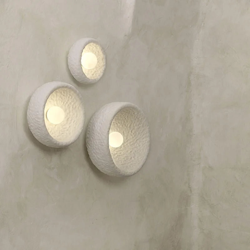 Trois appliques bohème chic disposées en ensemble sur un mur, créant un effet décoratif élégant.