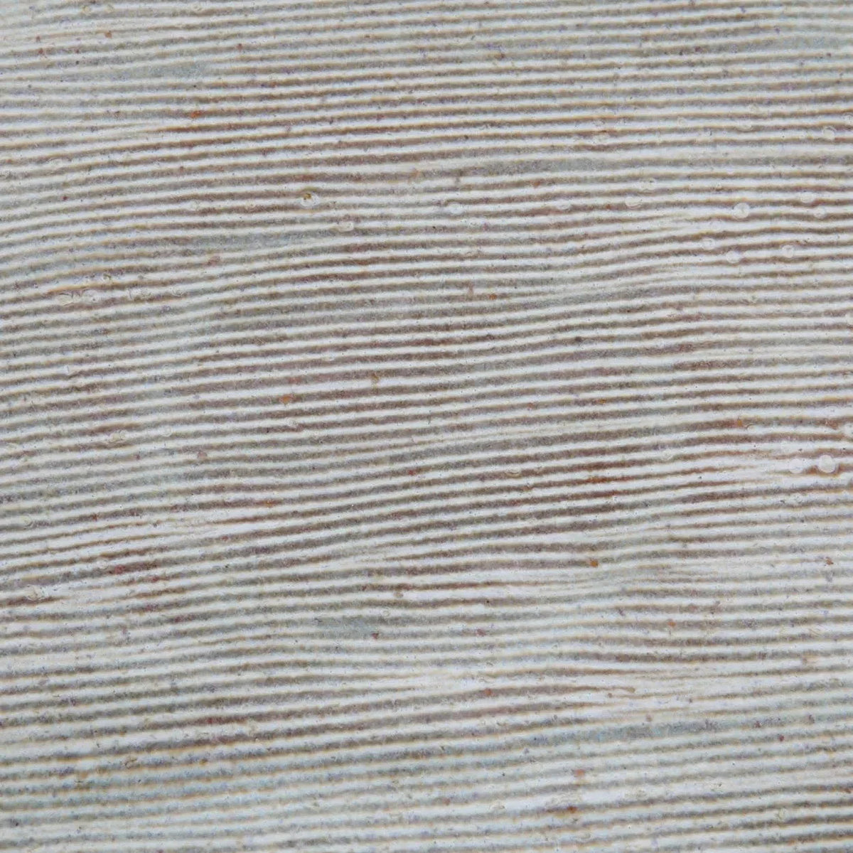 Assiette en grès artisanal gris clair à bord brun et motifs striés texturés