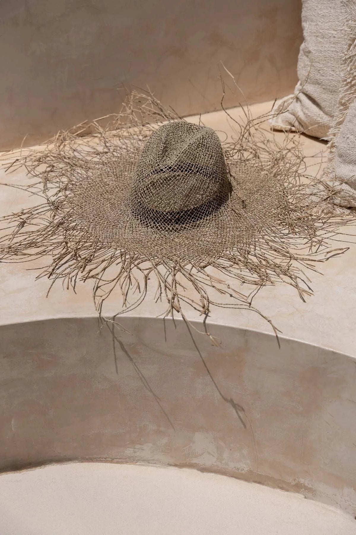 Chapeau de plage naturel en herbe marine texturé, large bord orné de brins délicats