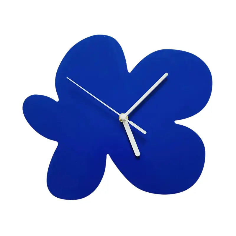 Gros plan sur l’horloge fleur abstraite bleue, aiguilles blanches et design unique.