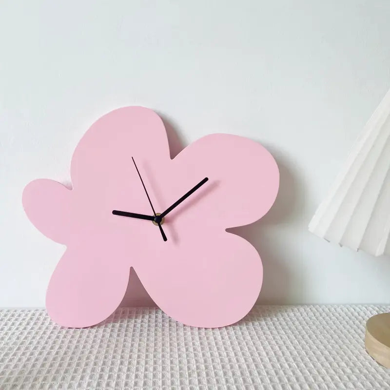 Horloge fleur abstraite rose posée sur une table, ambiance douce et minimaliste.
