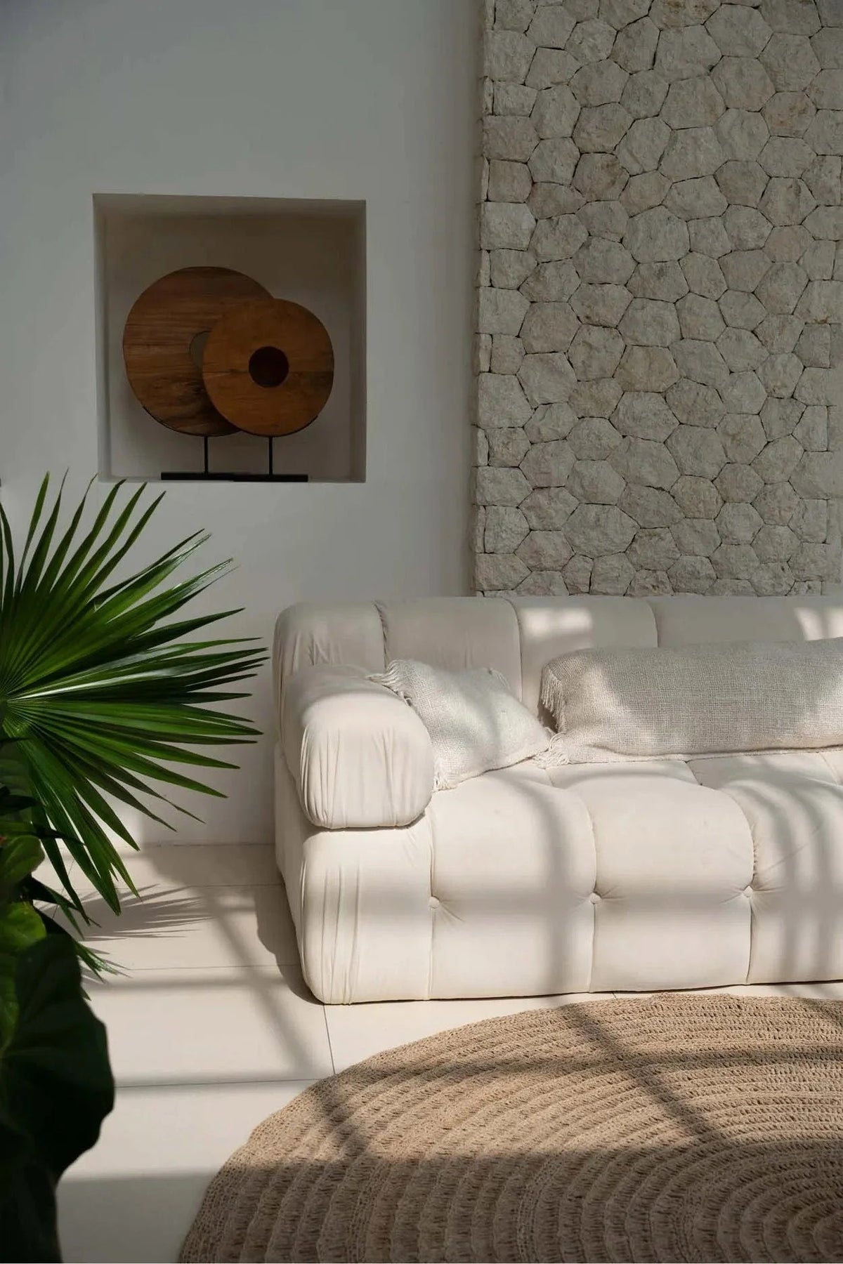 Canapé crème capitonné avec coussins doux et design minimaliste