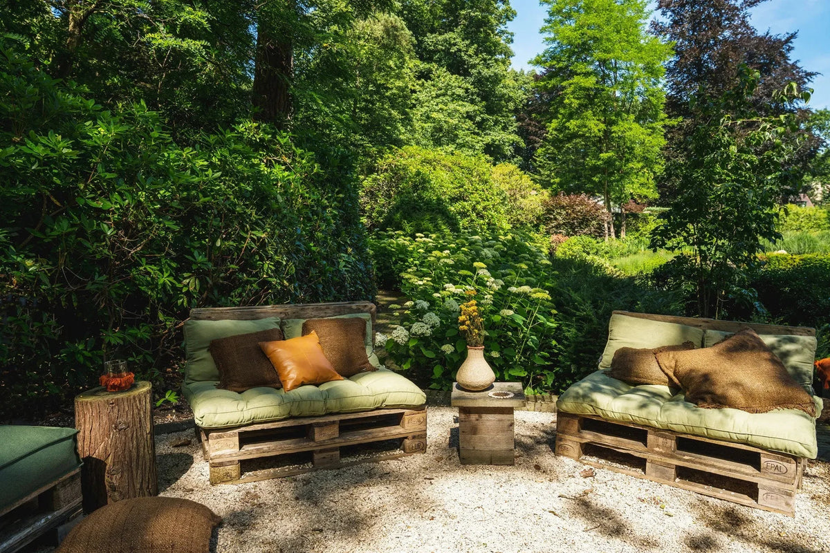 Espace extérieur avec mobilier en palettes en bois, coussins verts et coussins marron 60x60 cm