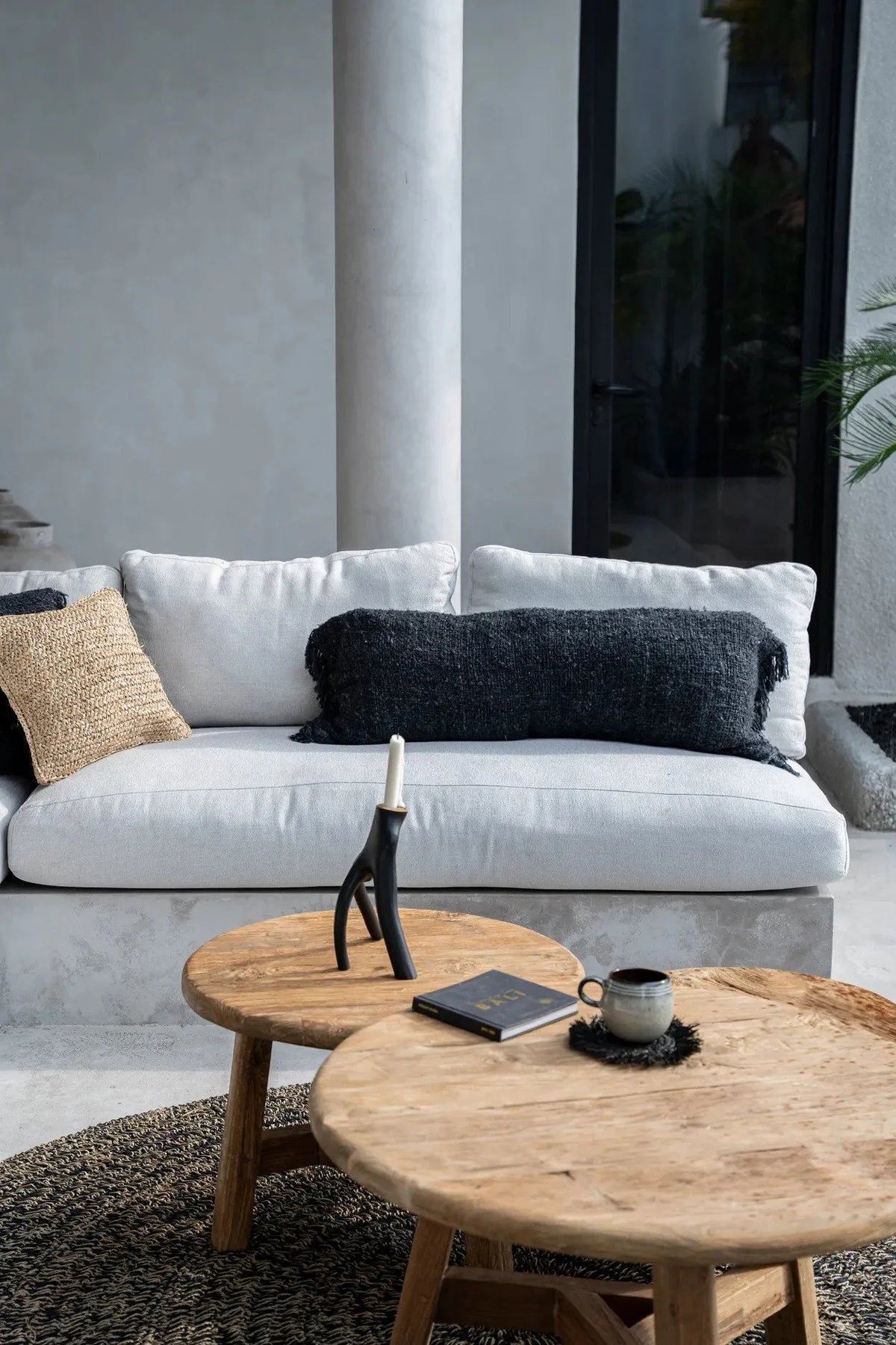 Canapé sectionnel moderne blanc avec coussins noir et beige, table basse bois