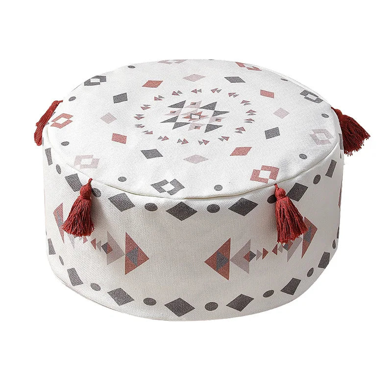 Housse de pouf rond avec un motif ethnique rouge et blanc, ornée de pompons, parfaite pour une ambiance cosy.