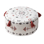 Housse de pouf rond avec un motif ethnique rouge et blanc, ornée de pompons, parfaite pour une ambiance cosy.