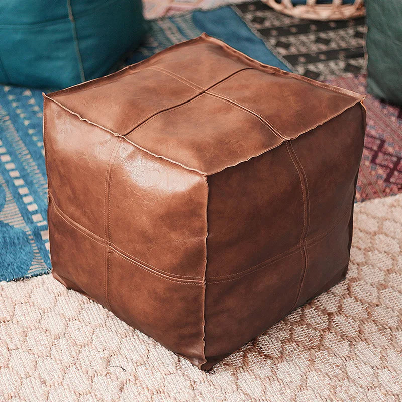 Housse de pouf marocain marron posée sur un tapis oriental, parfaite pour un intérieur authentique.