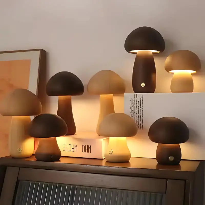 Groupe de lampes champignon en bois de différentes tailles et couleurs allumées, posées sur un meuble.