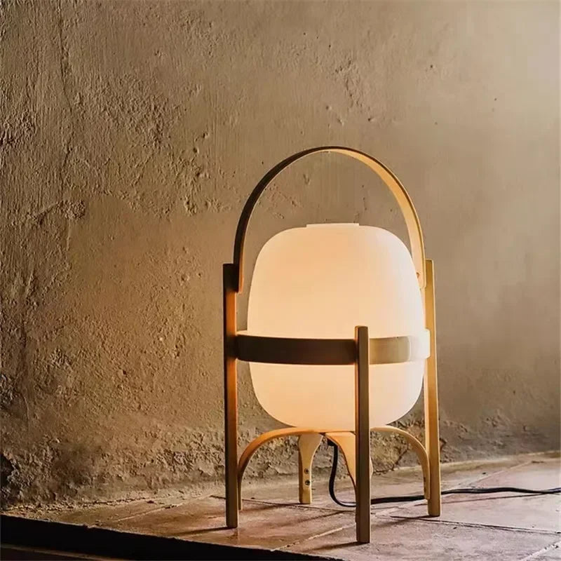 Lampe à pied en bois de taille moyenne avec abat-jour blanc, posée sur un sol