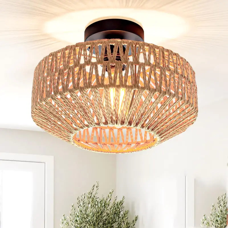 Luminaire plafonnier en rotin tressé allumé, projetant des motifs lumineux sur le plafond.