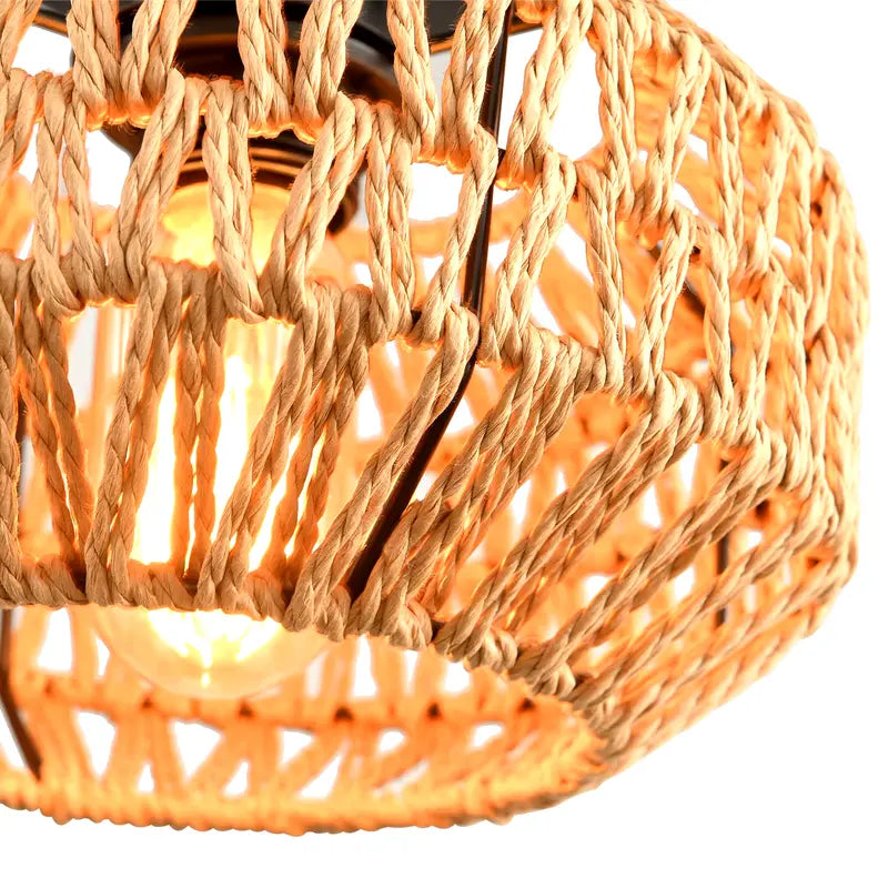 Gros plan sur le tressage du luminaire en rotin avec ampoule LED allumée.