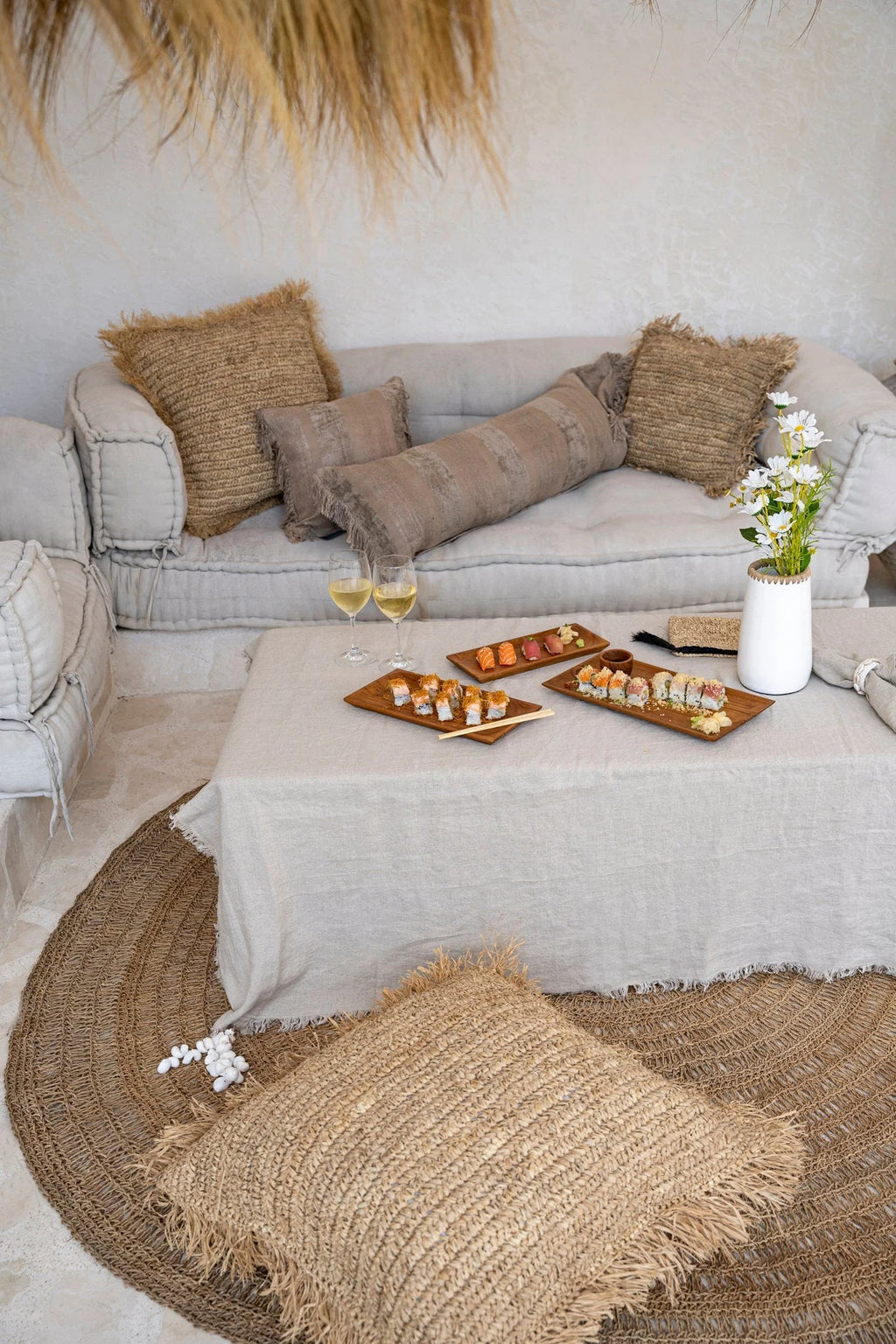 Canapé modulable beige avec coussins et table basse rectangulaire sushi et vin