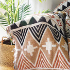 Vue détaillée du plaid bohème aux motifs ethniques, motifs aztèques en terracotta, noir et beige.