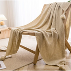 Couverture tricotée Beige Plaid Bohème drapée sur une chaise en bois