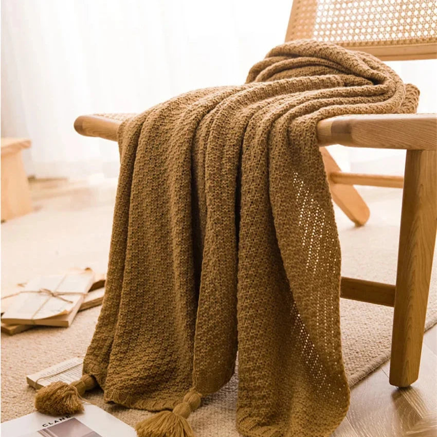 Couverture en laine plaid bohème beige aux franges drapée sur une chaise