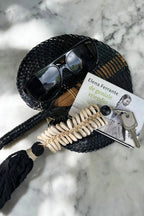 Éventail en paille noire tissée avec pompon et coquillages
