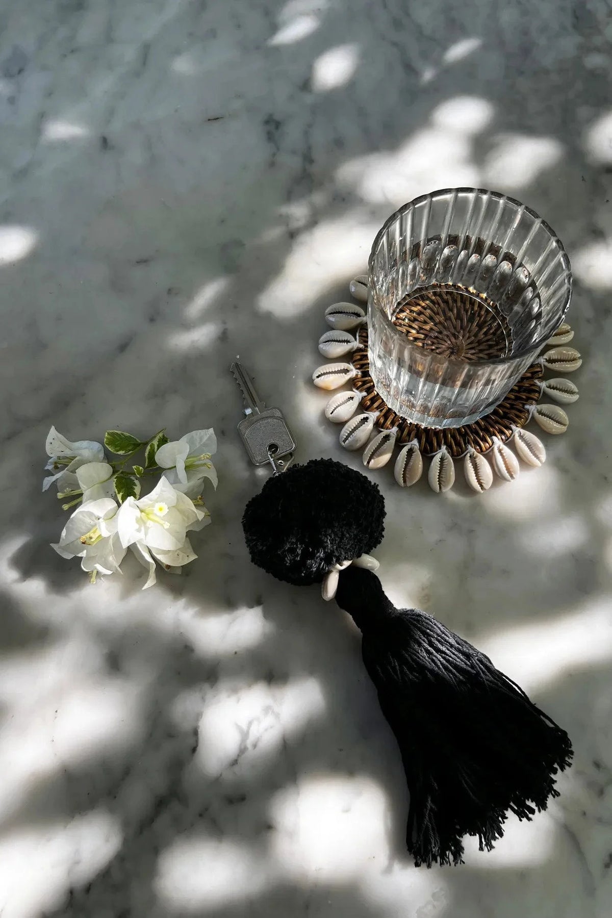 Porte-clés pompon noir en coton avec coquillage cauris blanc