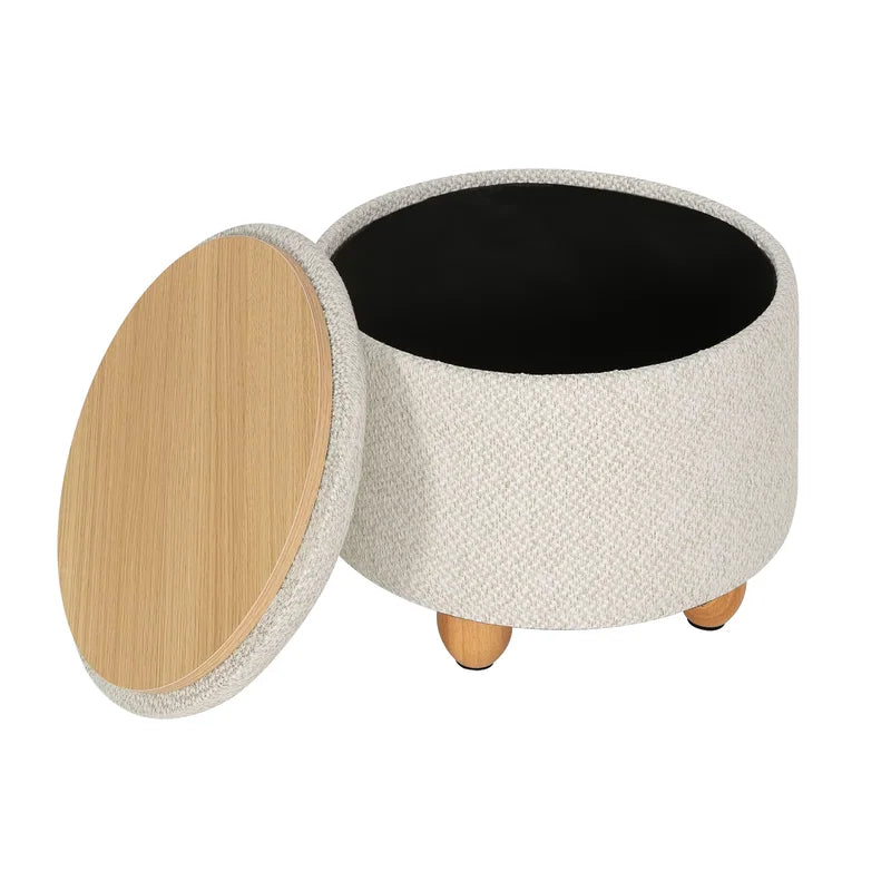 Pouf de rangement rond couleur crème avec couvercle amovible et pieds en bois naturel.
