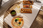Assortiment de cuisine japonaise avec sushi, edamame, riz coloré et vin blanc dans un saladier en teck naturel