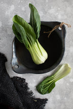 Bok choy frais dans bol céramique noir mat avec ficelle rustique