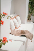 Chapeau oversize en jacinthe d’eau ondulée naturel Ø85 cm sur banc blanc
