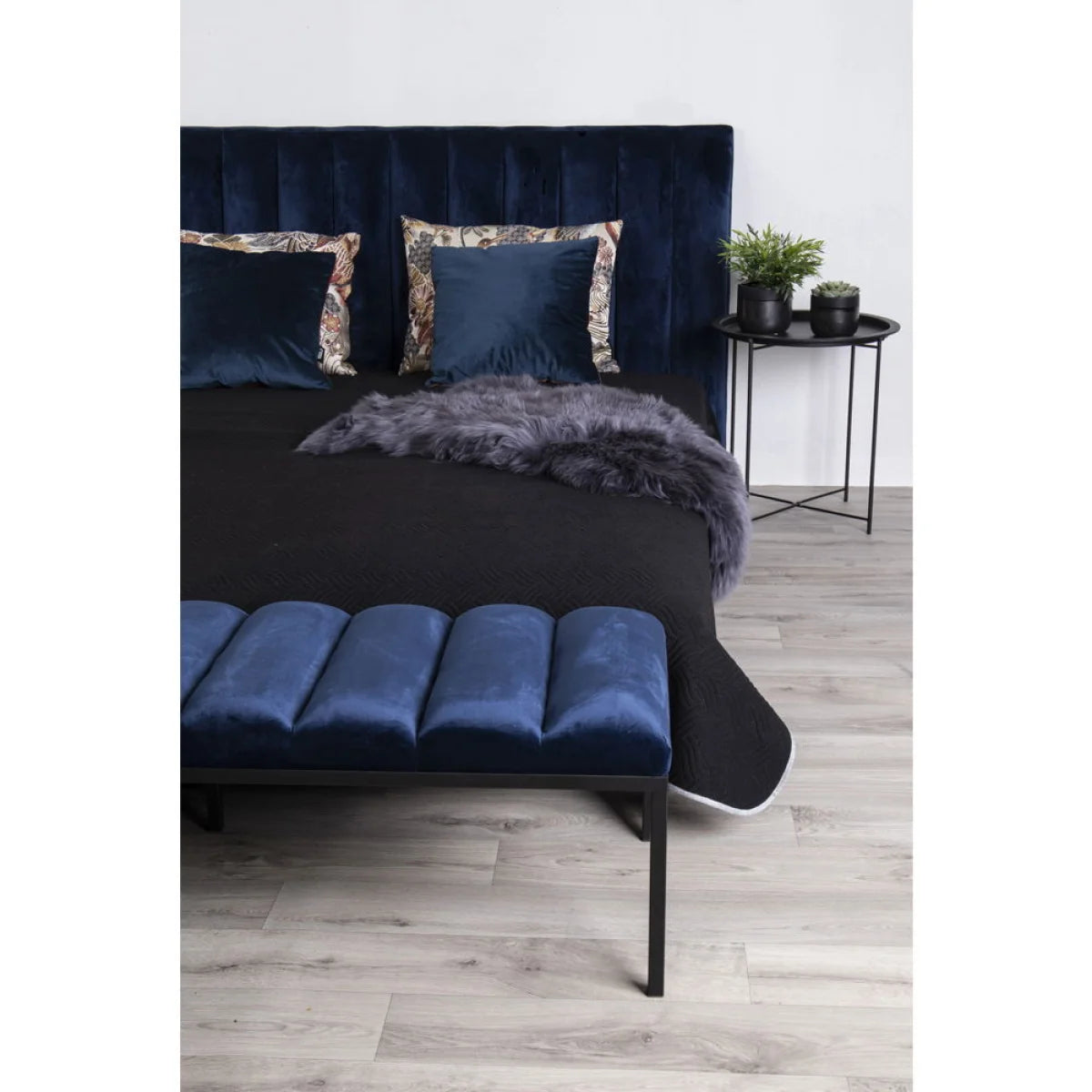 Lit de velours bleu profond avec têtière capitonnée et banc assorti