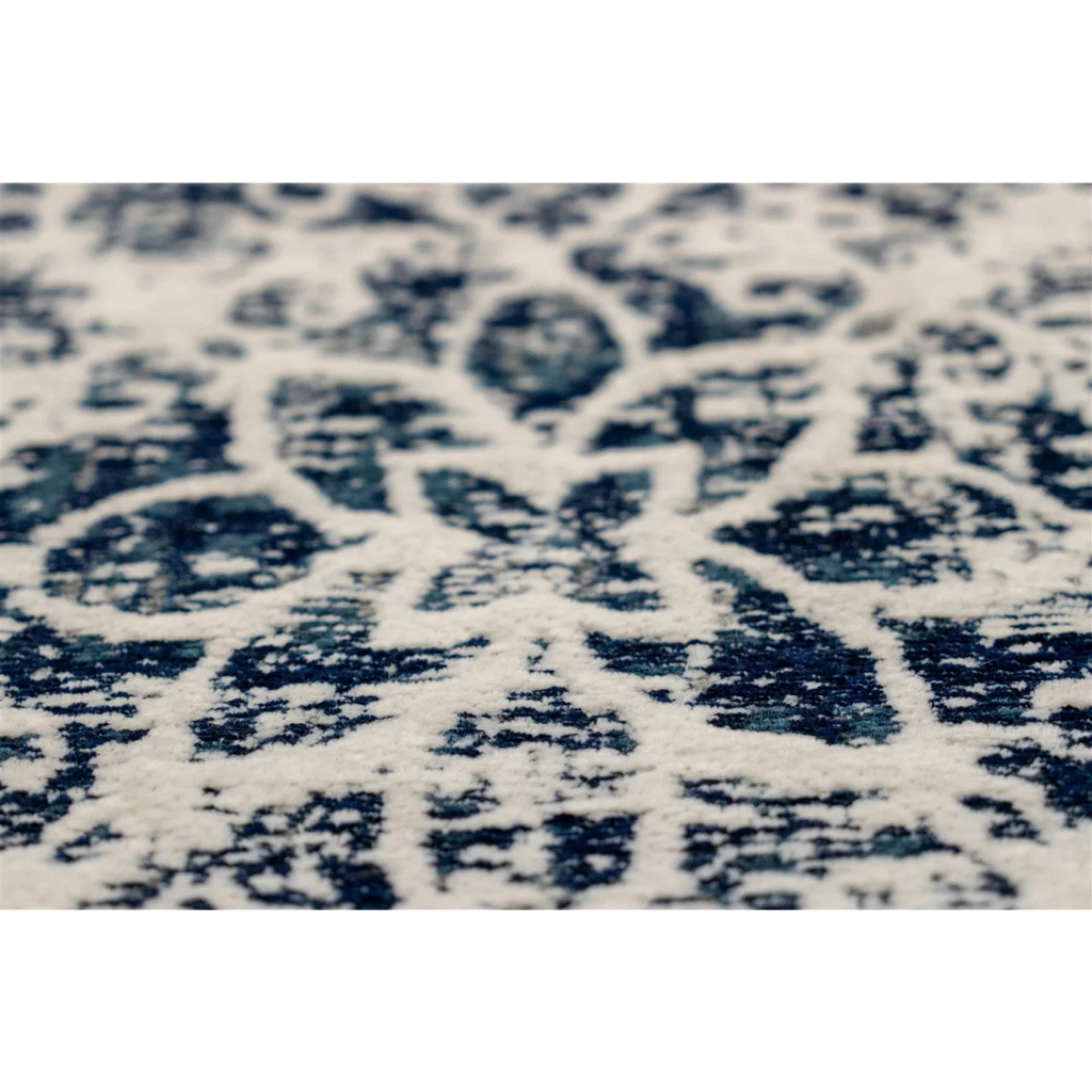 Vue rapprochée d un tapis oriental rectangulaire bleu et écru avec motif floral vieilli