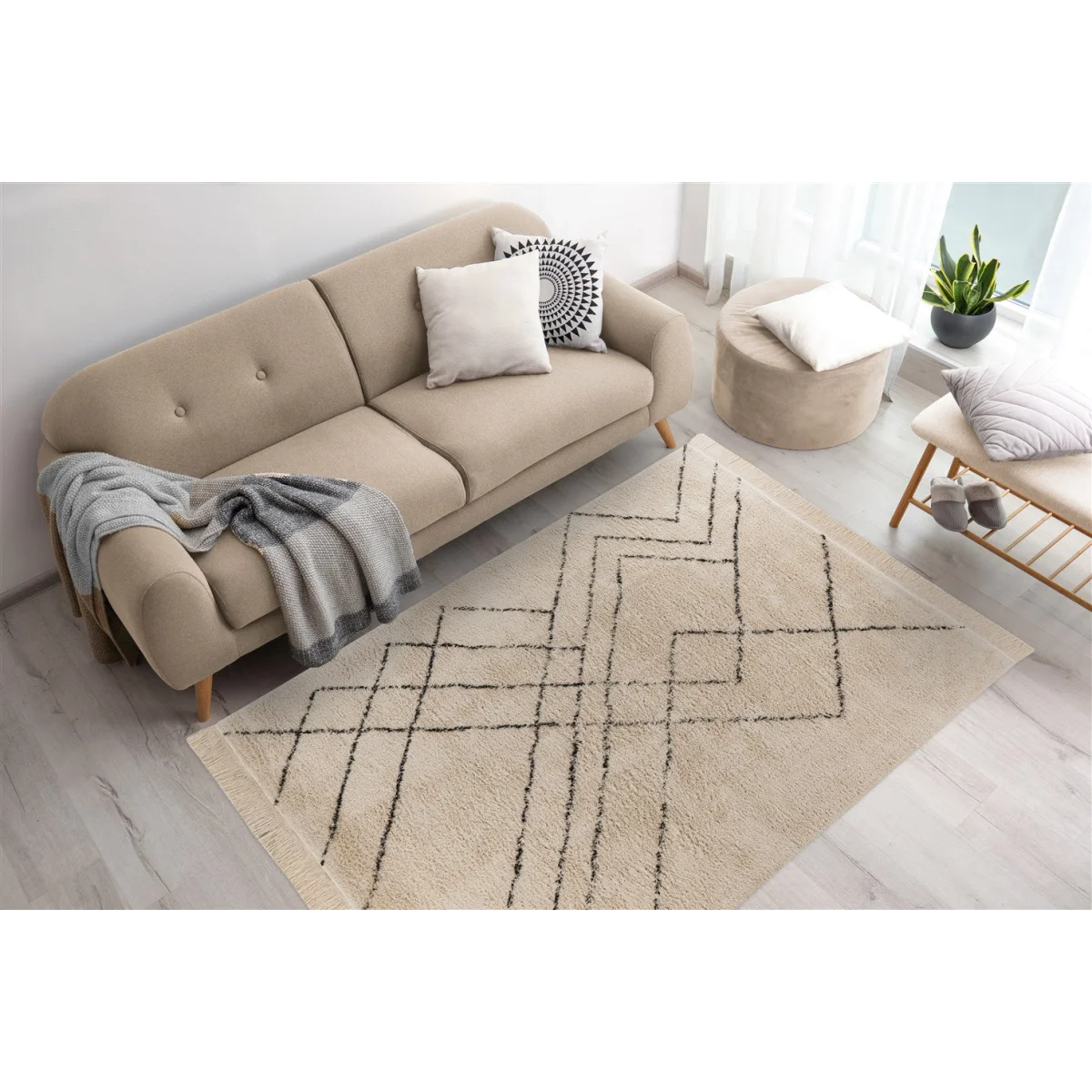 Canapé deux places en coton écru avec motifs noirs, franges et coussins décoratifs